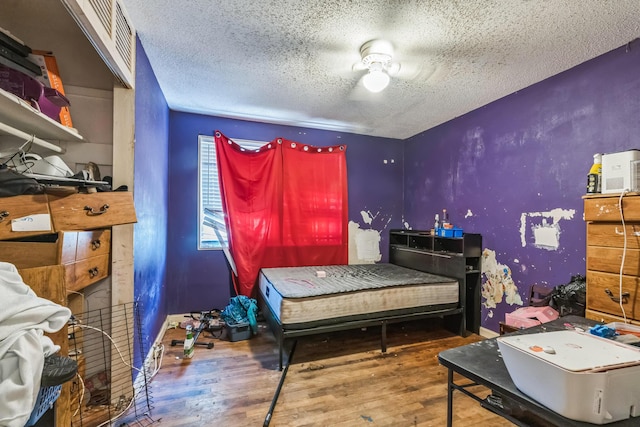 bedroom with wood finished floors and a textured ceiling