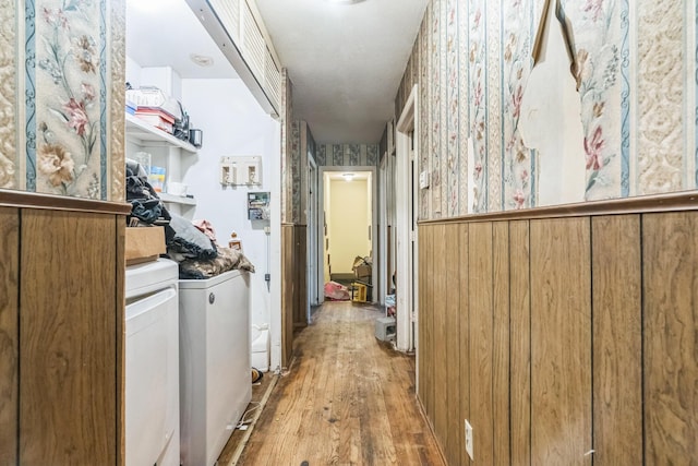 interior space with washer and dryer, wood finished floors, and wallpapered walls