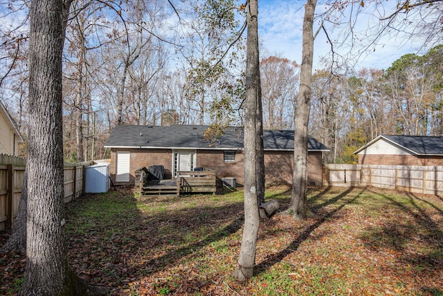 rear view of house featuring a wooden deck and a yard