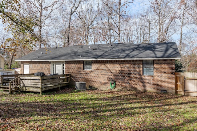 back of house featuring a deck, cooling unit, and a lawn