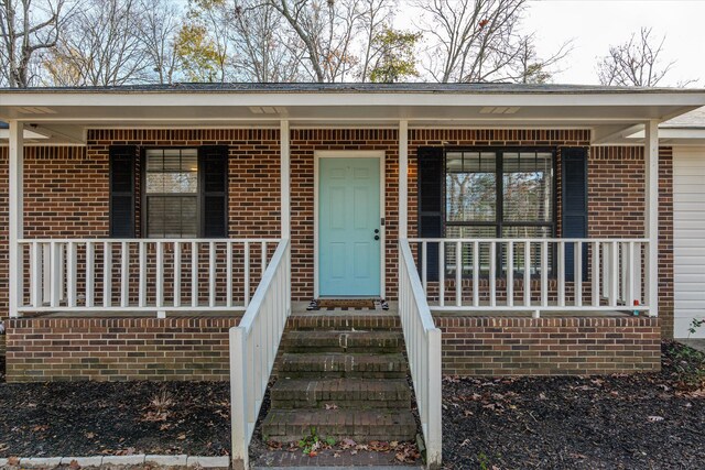 view of exterior entry featuring a porch