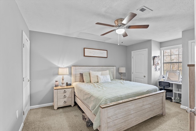 bedroom with ceiling fan, light carpet, and a textured ceiling