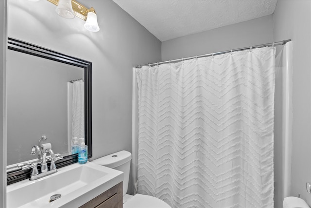 bathroom with a shower with curtain, vanity, toilet, and a textured ceiling