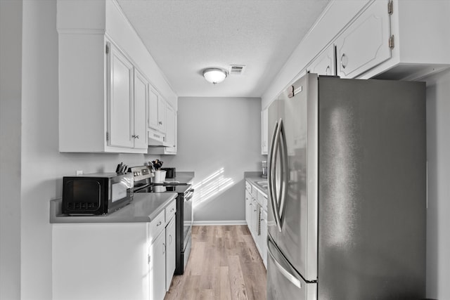 kitchen featuring a textured ceiling, stainless steel appliances, light hardwood / wood-style flooring, white cabinetry, and range hood