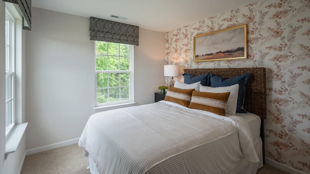 carpeted bedroom with baseboards, visible vents, and wallpapered walls