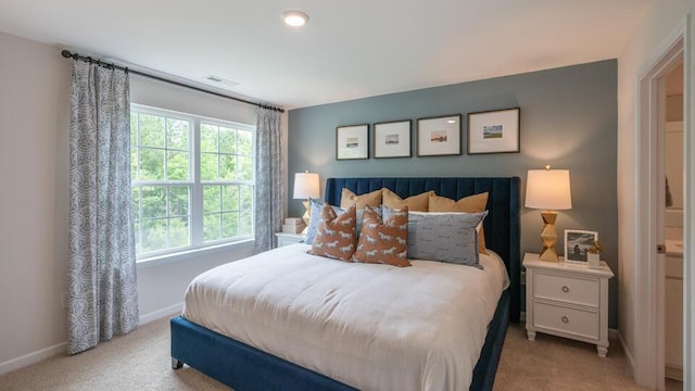 bedroom with light carpet, visible vents, and baseboards