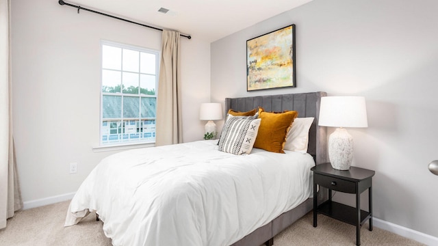 bedroom featuring light carpet, visible vents, and baseboards