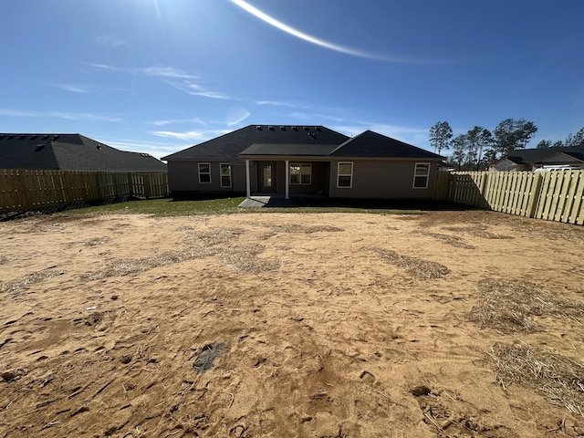 back of house with a fenced backyard