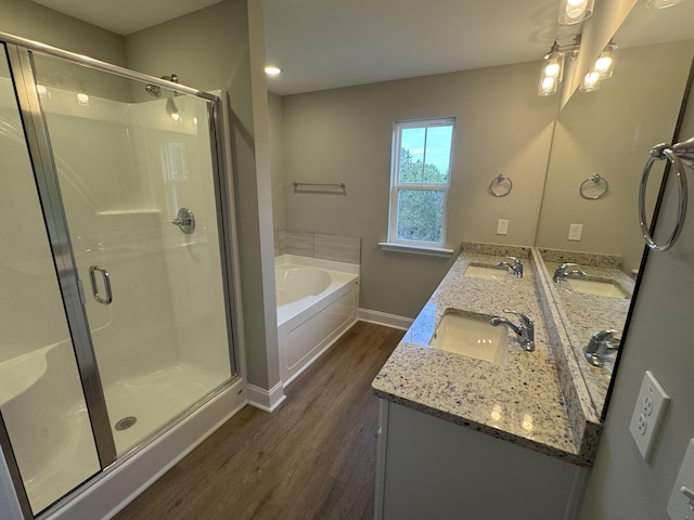 full bath with a garden tub, wood finished floors, and a sink