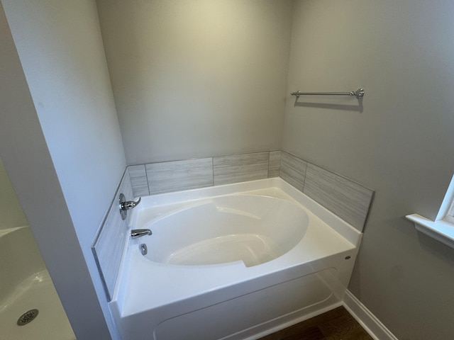 bathroom featuring wood finished floors and a garden tub