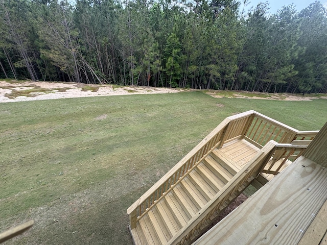 view of yard with a wooden deck and a view of trees