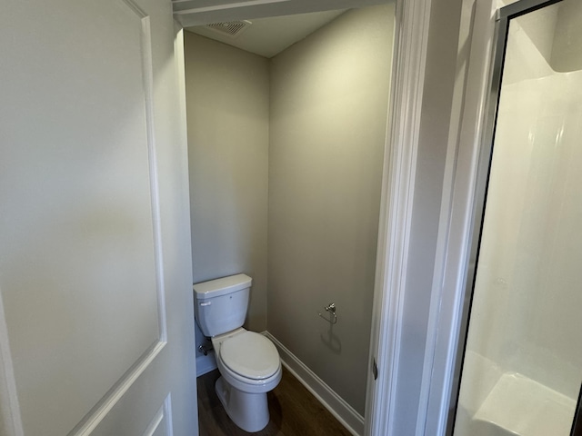bathroom with a shower stall, wood finished floors, visible vents, toilet, and baseboards