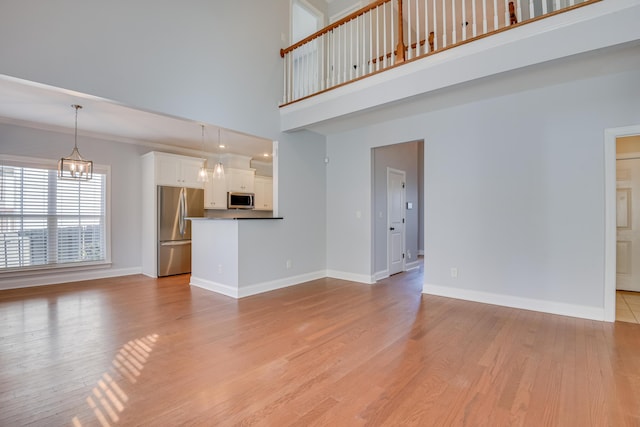 524 Jutland Way, Evans, GA 30809 - unfurnished living room featuring light wood-style floors, a chandelier, and a towering ceiling