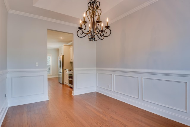 524 Jutland Way, Evans, GA 30809 - unfurnished room featuring a chandelier, crown molding, wood finished floors, a wainscoted wall, and a decorative wall