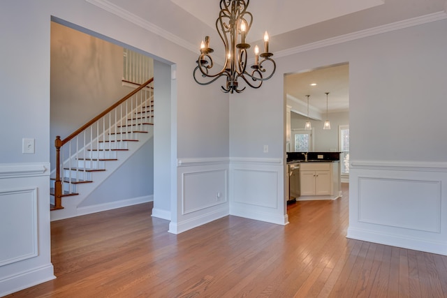 524 Jutland Way, Evans, GA 30809 - unfurnished dining area with stairs, wood-type flooring, ornamental molding, a chandelier, and wainscoting