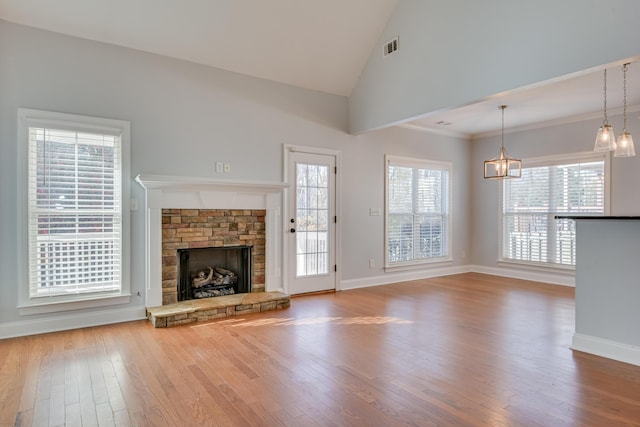 524 Jutland Way, Evans, GA 30809 - unfurnished living room with wood finished floors, a stone fireplace, healthy amount of natural light, a chandelier, and high vaulted ceiling