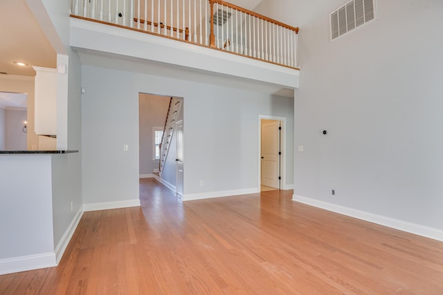 524 Jutland Way, Evans, GA 30809 - unfurnished living room with a towering ceiling, light wood-type flooring, and stairs