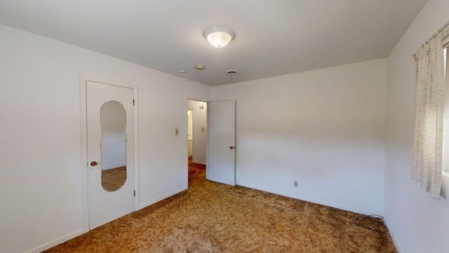 unfurnished bedroom featuring carpet flooring and baseboards