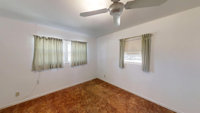 carpeted spare room with baseboards and ceiling fan