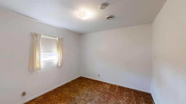 unfurnished room with visible vents, baseboards, and carpet