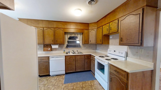 kitchen featuring a sink, visible vents, white appliances, and brown cabinets