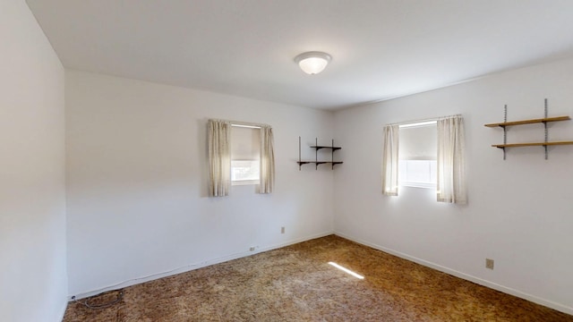 carpeted spare room with baseboards