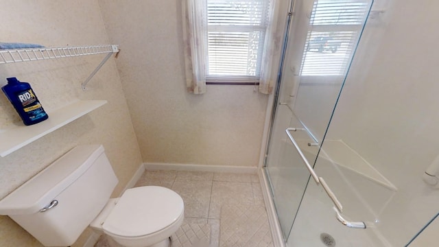 full bath with a shower stall, toilet, baseboards, and tile patterned floors