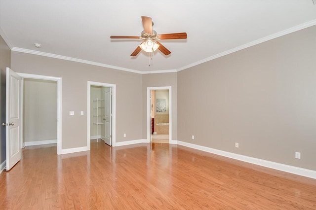 unfurnished bedroom with baseboards, light wood-style floors, ensuite bath, and crown molding