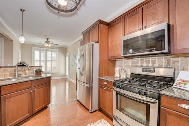 kitchen featuring a sink, crown molding, brown cabinets, and stainless steel appliances