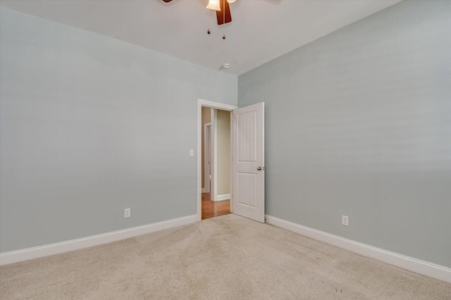 empty room featuring baseboards, light carpet, and ceiling fan