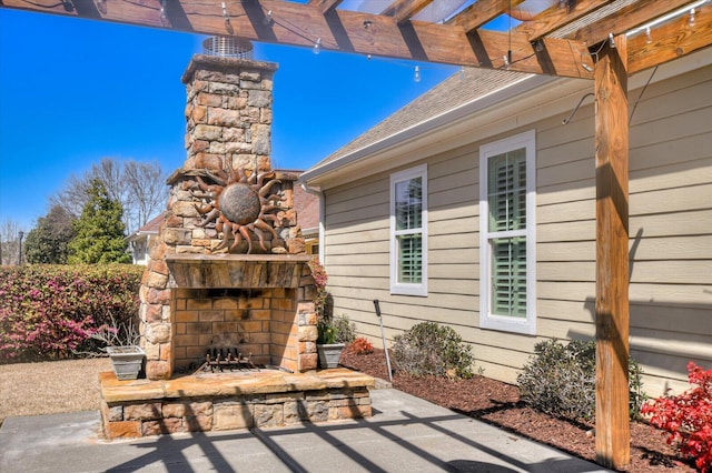 view of patio / terrace featuring a pergola and an outdoor stone fireplace