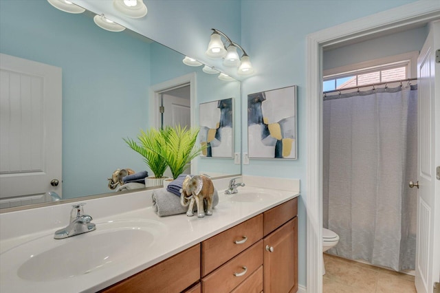 bathroom featuring tile patterned flooring, double vanity, toilet, and a sink