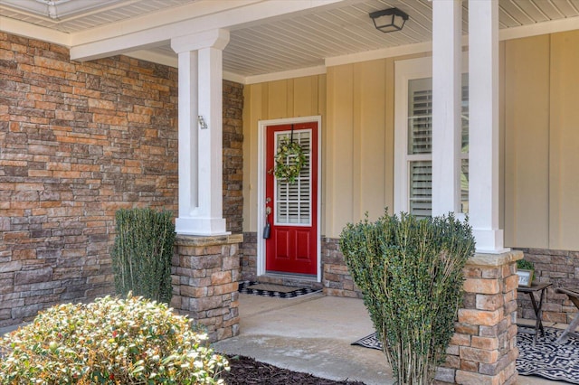 entrance to property featuring stone siding, brick siding, and a porch