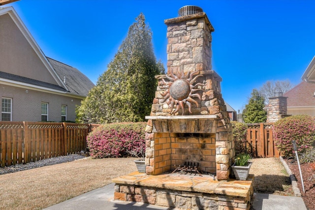 view of patio / terrace featuring an outdoor stone fireplace and a fenced backyard