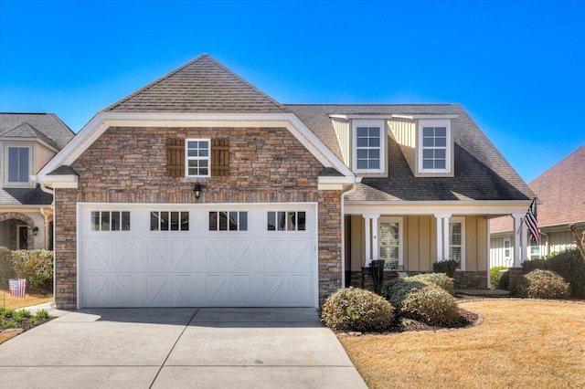 view of front of home with stone siding, an attached garage, a shingled roof, and driveway