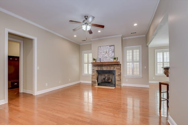 unfurnished living room with plenty of natural light, a stone fireplace, and light wood-style floors