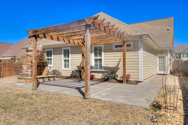 back of property featuring fence, roof with shingles, a yard, a patio area, and a pergola