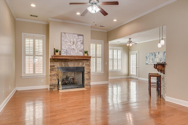 living room featuring visible vents, wood finished floors, a fireplace, and ornamental molding