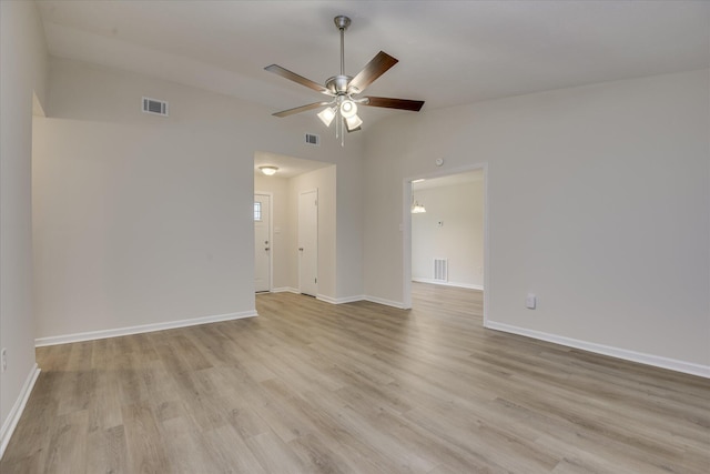 empty room with lofted ceiling, a ceiling fan, light wood-type flooring, and baseboards
