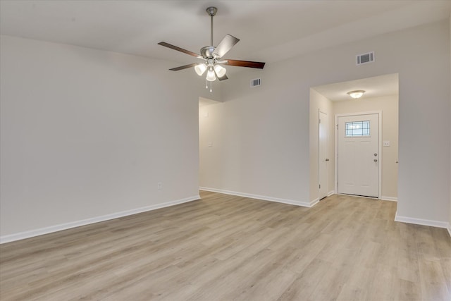 empty room featuring light wood finished floors, baseboards, and ceiling fan