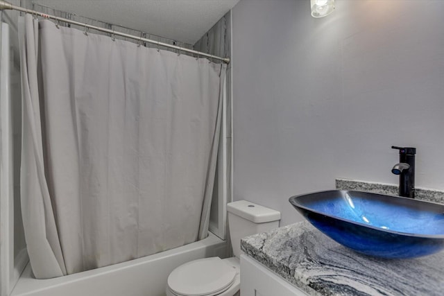 full bathroom with vanity, shower / bath combination with curtain, a textured ceiling, and toilet