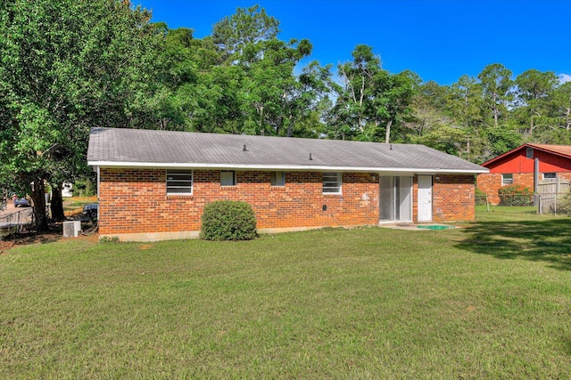 rear view of house featuring a lawn and cooling unit