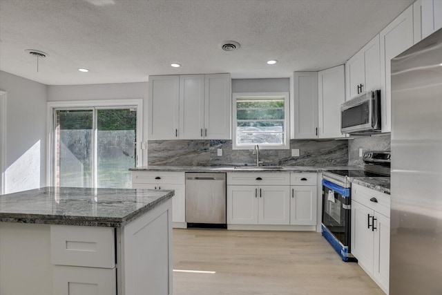 kitchen featuring white cabinetry, sink, appliances with stainless steel finishes, and tasteful backsplash