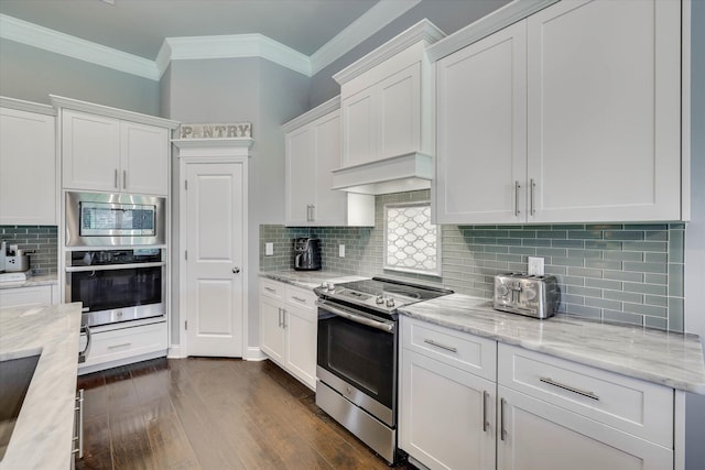 1856 Preservation Cir, Evans, GA 30809 - kitchen featuring appliances with stainless steel finishes, crown molding, white cabinetry, decorative backsplash, and dark wood finished floors