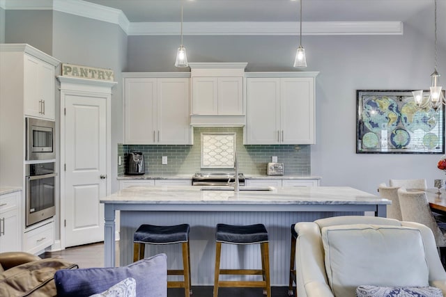 1856 Preservation Cir, Evans, GA 30809 - kitchen featuring stainless steel appliances, crown molding, backsplash, white cabinets, and a breakfast bar area