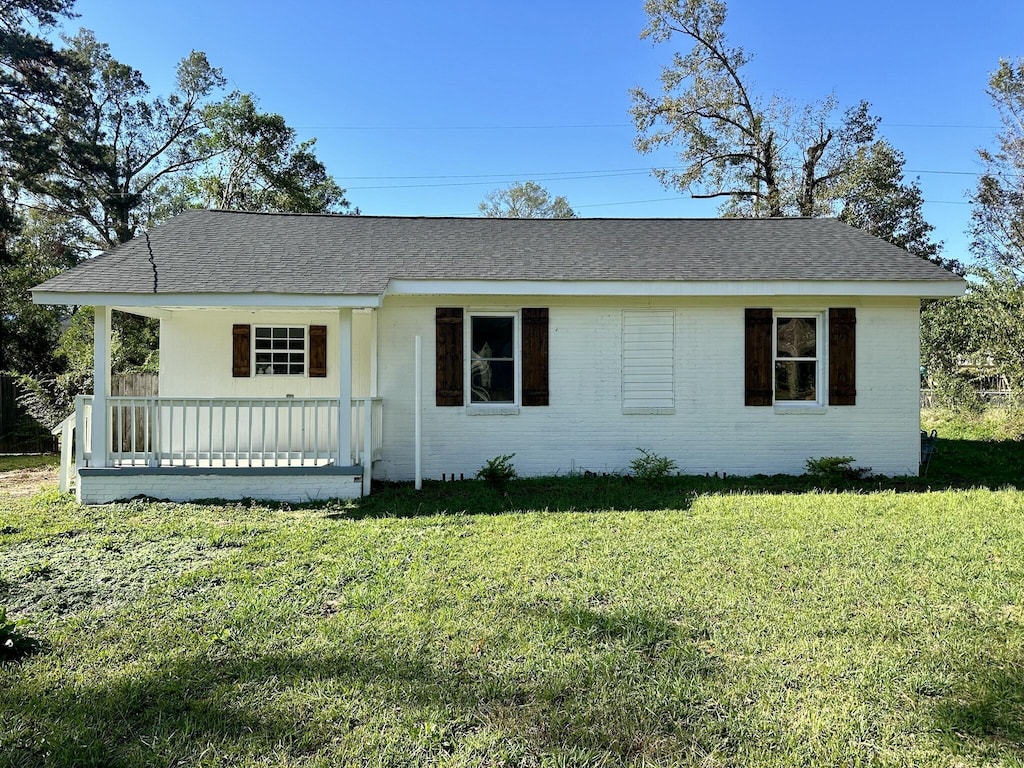 ranch-style house with covered porch and a front lawn