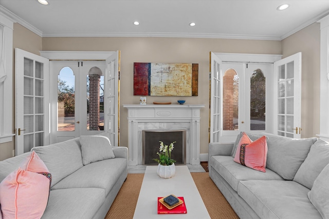 living room with recessed lighting, a premium fireplace, ornamental molding, and french doors