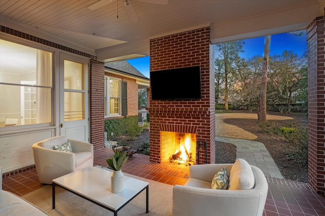 view of patio / terrace with ceiling fan and an outdoor living space with a fireplace