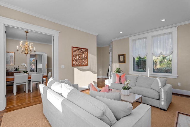 living area featuring a chandelier, baseboards, wood finished floors, and crown molding