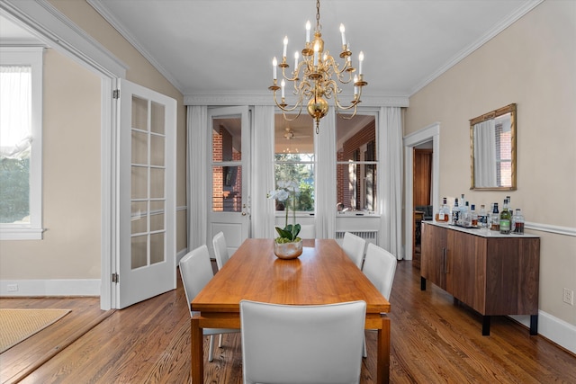 dining area featuring a wealth of natural light, ornamental molding, and wood finished floors